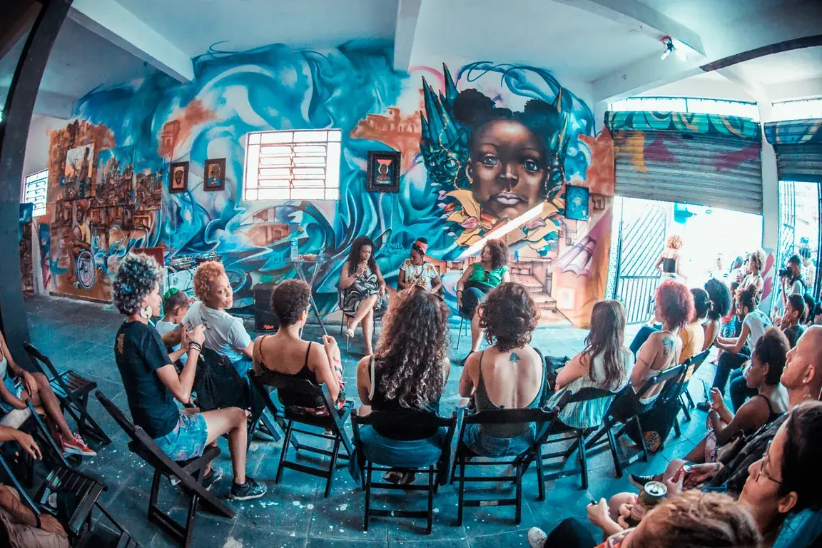 Roda de conversa entre mulheres na Ocupação Femi OPNI, em espaço com murais da Favela Galeria.